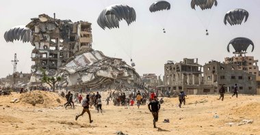 People rush to collect humanitarian aid packages landing amid Israeli attacks over the northern Gaza Strip, Palestine, April 23, 2024. (AFP Photo)