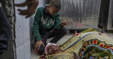 Ismail Faraj mourns over the body of his brother Shadi, 14, inside the morgue of al-Aqsa Hospital, following an Israeli attack on Bureije refugee camp, central Gaza Strip, Dec. 4, 2024. (EPA Photo)