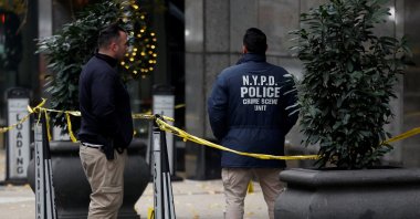 Law enforcement officers work near evidence markers placed where shell casings were found at the scene where the CEO of UnitedHealthcare, Brian Thompson, was reportedly shot and killed in Midtown Manhattan, New York City, U.S., Dec. 4, 2024. (Reuters Photo)