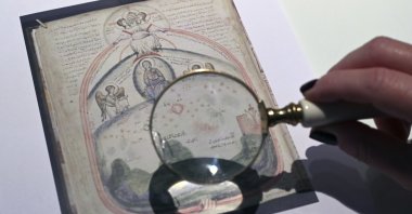 Christina Sotirakoglou, a handwriting expert, observes Byzantine paintings based on photographs prints, at her office, Thessaloniki, northern Greece, Nov. 30, 2024. (AP Photo)