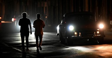 People walk at night on a street during a nationwide blackout caused by a grid failure in Havana, Cuba, Dec. 4, 2024. (AFP Photo)