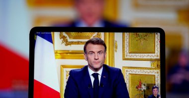 French President Emmanuel Macron appears on screen as he makes a television address to the nation after Prime Minister Michel Barnier's government was toppled in a no-confidence vote in parliament in Paris, France, Dec. 5, 2024. (Reuters Photo)