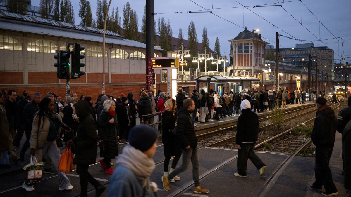 People cross tram tracks on &quot;Warschauer Strasse&quot; street near the subway station, Berlin, Germany, Nov. 16, 2024. (Reuters Photo)