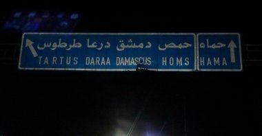 Vehicles drive near a sign on a road to Hama after anti-regime forces captured the city during their advance across the north, Hama, Syria, Dec. 5, 2024. (Reuters Photo)