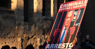 A demonstrator holds up a placard with Israeli Prime Minister Netanyahu behind bars and reads in Italian words, "Criminal against humanity, let's arrest him now" during a rally in support of Palestinians, Rome, Italy, Nov. 30, 2024. (AFP Photo)