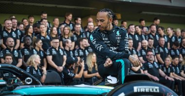 Mercedes' British driver Lewis Hamilton sits on his car as he arrives to pose for a group photo with his team ahead of the Abu Dhabi Formula One Grand Prix at the Yas Marina Circuit, Abu Dhabi, UAE, Dec. 5, 2024. (AFP Photo)
