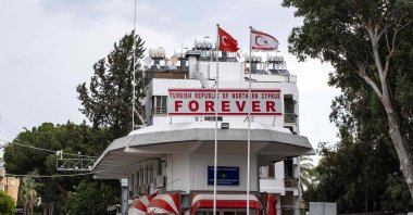 Flags of Türkiye and the Turkish Republic of Northern Cyprus (TRNC) fly above a checkpoint controlled by the TRNC leading to the U.N. buffer zone on the island, in the northern part of the divided capital Lefkoşa (Nicosia), Turkish Cyprus, July 11, 2024. (AFP Photo)