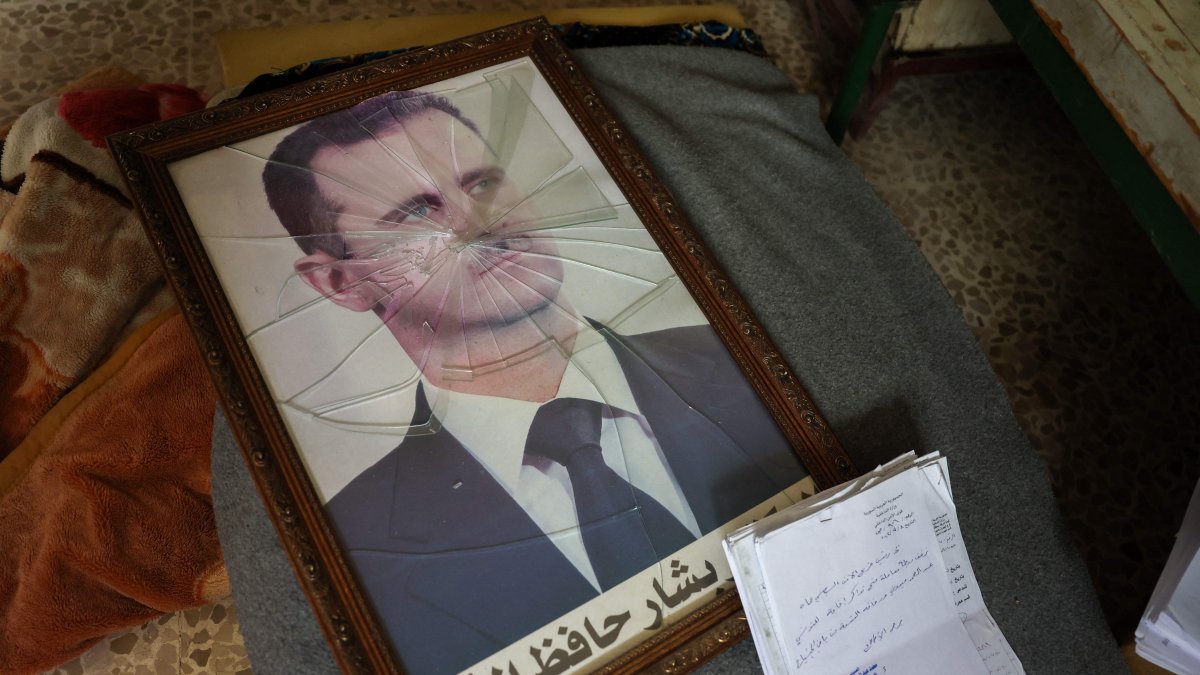 A portrait of Bashar Assad is pictured with its frame broken at a regime facility on the outskirts of the central city of Hama, following the capture of the area by anti-regime forces, Syria, Dec. 7, 2024. (AFP Photo)