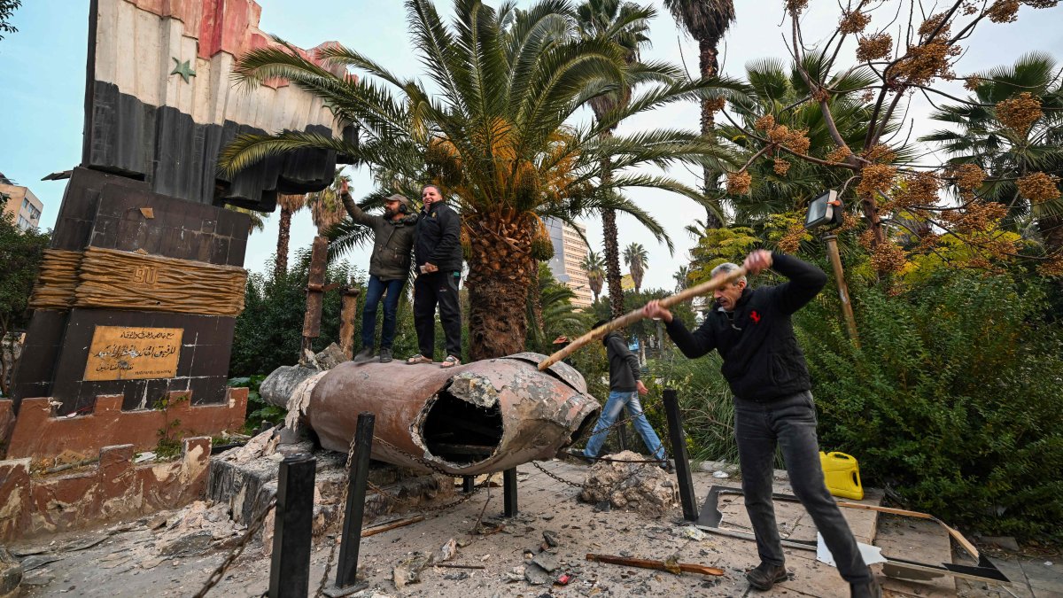 People stand atop a toppled statue of Syria’s late president Hafez al-Assad in Damascus, Syria, Dec. 8, 2024. (AFP Photo)