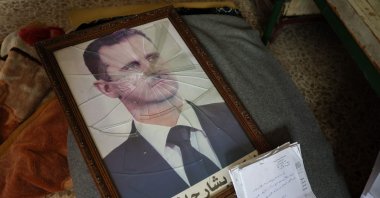 A portrait of Bashar Assad is pictured with its frame broken at a regime facility on the outskirts of the central city of Hama, following the capture of the area by anti-regime forces, Syria, Dec. 7, 2024. (AFP Photo)