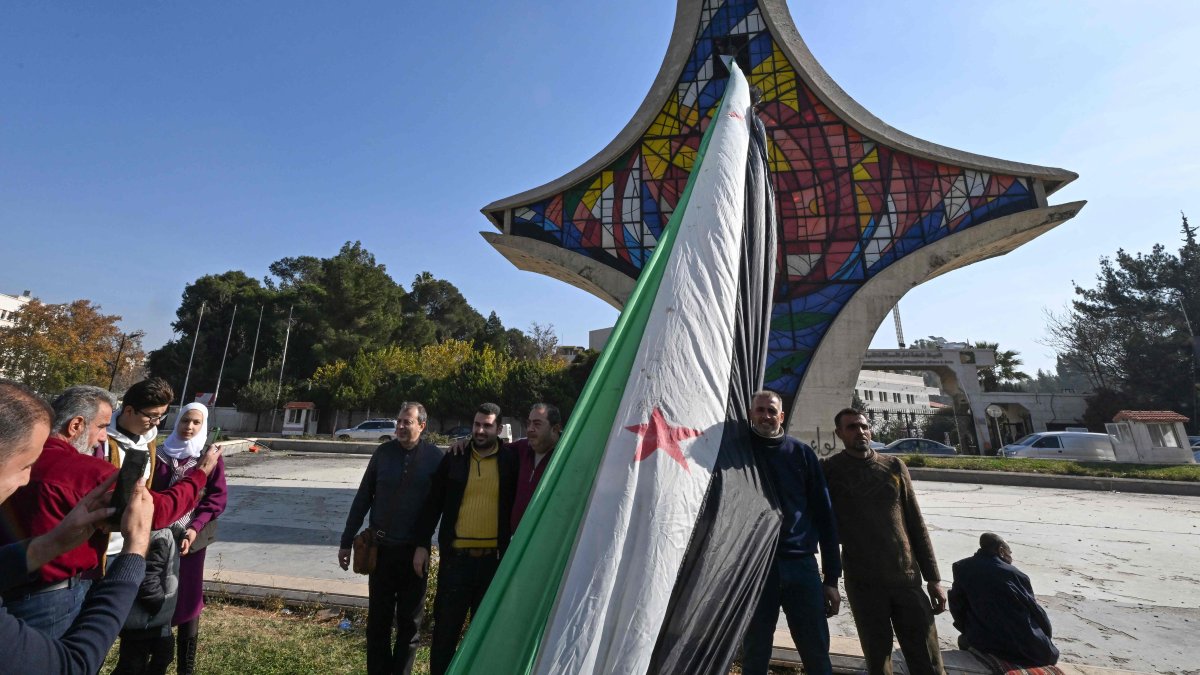 People celebrate with a large Syrian opposition flag at Umayyad Square, Damascus, Syria, Dec. 9, 2024. (AFP Photo)