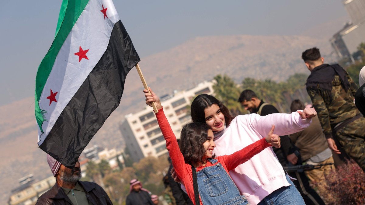 A girl poses for photos waving a Syrian opposition flag at Umayyad Square in Damascus, Syria, Dec. 9, 2024. (AFP Photo)