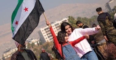 A girl poses for photos waving a Syrian opposition flag at Umayyad Square in Damascus, Syria, Dec. 9, 2024. (AFP Photo)