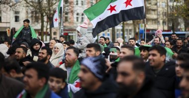 Syrians wave Syrian opposition flags at a rally in Wuppertal, Germany, Dec. 8, 2024. (AP Photo)