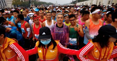 Volunteers form a human chain as participants wait before the Beijing Marathon, at Tiananmen Square, Beijing, China, Oct. 29, 2023. (Reuters Photo)
