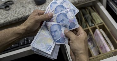 A currency exchange office worker counts Turkish lira banknotes, Istanbul, Türkiye, Aug. 9, 2018. (EPA Photo)