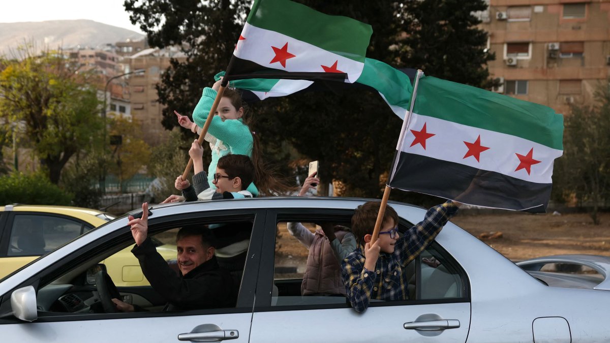 People celebrate the ousting of regime leader Bashar Assad and ending five decades of Baath rule with the Syrian opposition flag, Damascus, Syria, Dec. 10, 2024. (AFP Photo)