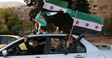 People celebrate the ousting of regime leader Bashar Assad and ending five decades of Baath rule with the Syrian opposition flag, Damascus, Syria, Dec. 10, 2024. (AFP Photo)