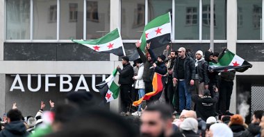 Members of the Syrian community hold flags of Syria and Germany as they rally to celebrate the end of Syrian dictator Bashar Assad&#039;s rule, Berlin, Germany, Dec. 8, 2024.