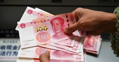 An employee counts 100-yuan notes at a bank in Beijing, China, Nov. 14, 2024. (AFP Photo)