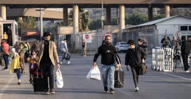 Syrians walk with their belongings on the Turkish side of the Cilvegözu Border Gate, between Türkiye and Syria, in the Reyhanli district of Hatay, Türkiye, Dec. 10, 2024. (EPA Photo)