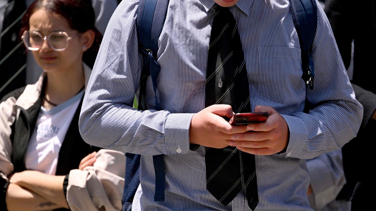 A schoolboy looks at his phone, Melbourne, Australia, Nov. 27, 2024. (AFP Photo)