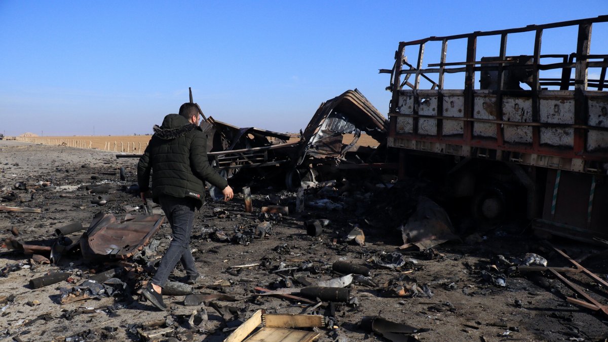 A member of the PKK/YPG terrorist group inspects a destroyed truck after a Turkish airstrike near Qamishli, northeast Syria, Dec. 11, 2024. (EPA Photo)