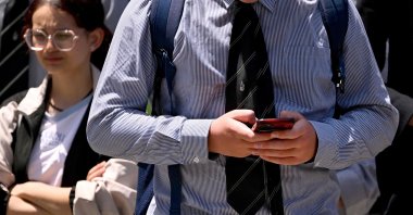 A schoolboy looks at his phone, Melbourne, Australia, Nov. 27, 2024. (AFP Photo)