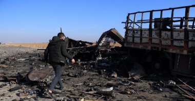 A member of the PKK/YPG terrorist group inspects a destroyed truck after a Turkish airstrike near Qamishli, northeast Syria, Dec. 11, 2024. (EPA Photo)