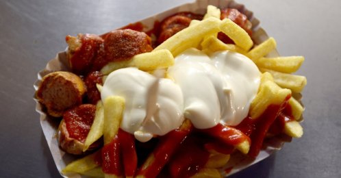 "Currywurst" with french fries, mayonnaise and ketchup, a typical German fast food dish, are placed at a Curry 36 stand, Berlin, Germany, Nov. 17, 2024. (Reuters Photo)