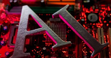 AI (artificial intelligence) letters are placed on a computer motherboard in this illustration taken June 23, 2023. (Reuters Photo)