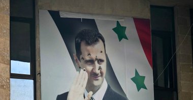 A bullet-riddled poster of toppled Syrian regime leader Bashar Assad hangs on a building, Aleppo, Syria, Dec. 12, 2024. (AFP Photo)
