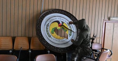 An anti-regime fighter breaks a sign at the Baath party offices, Damascus, Syria, Dec. 12, 2024. (AFP Photo)