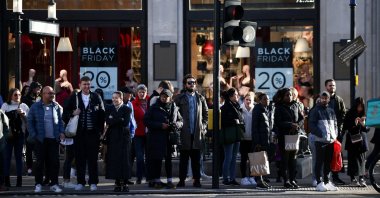 People stand near Black Friday signage in shop windows during Black Friday on Oxford Street, London, Britain, Nov. 25, 2022. (Reuters Photo)