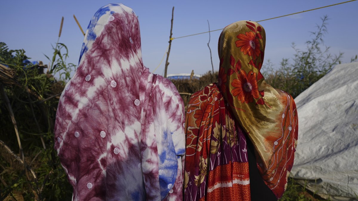 Women who fled war in Sudan and requested anonymity because they feared retribution after reporting sexual exploitation, walk in a refugee camp in Adre, Chad, Oct. 5, 2024. (AP Photo)