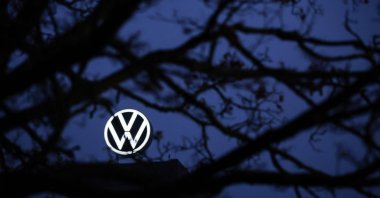 The logo of German carmaker Volkswagen (VW) is seen behind a tree at the company's headquarters in Wolfsburg, Germany, Dec. 4, 2024. (AFP Photo)
