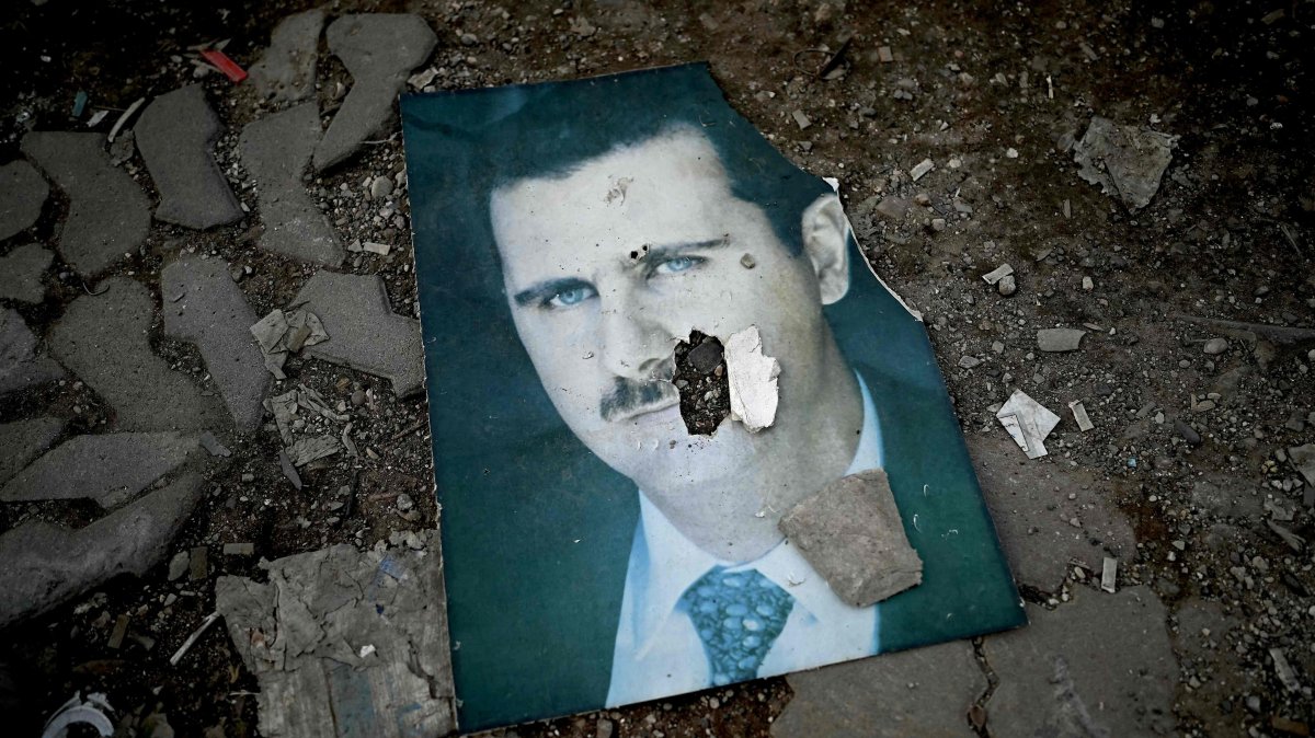 A damaged portrait of Syria&#039;s ousted regime leader Bashar Assad lies on the ground in the port city of Latakia, Syria, Dec. 15, 2024. (AFP Photo)