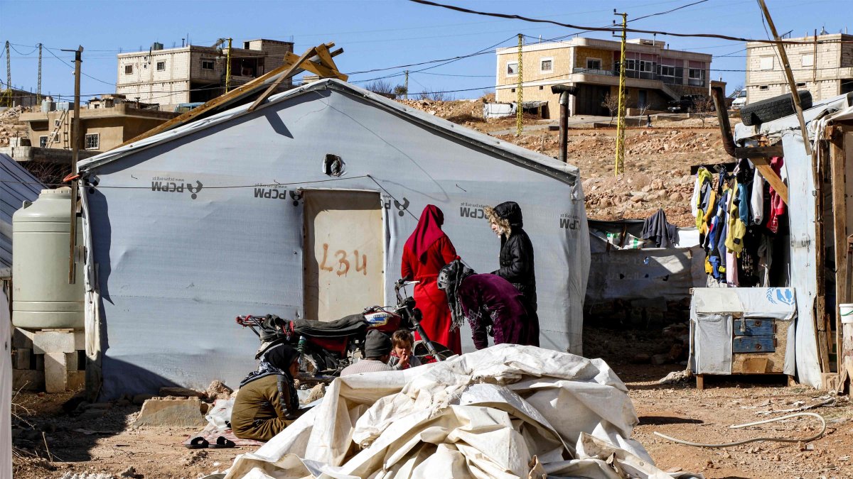 Syrian refugees stand outside a tent about to be dismantled at a camp in Arsal in eastern Lebanon before returning to Syria, Dec. 16, 2024. (AFP Photo)