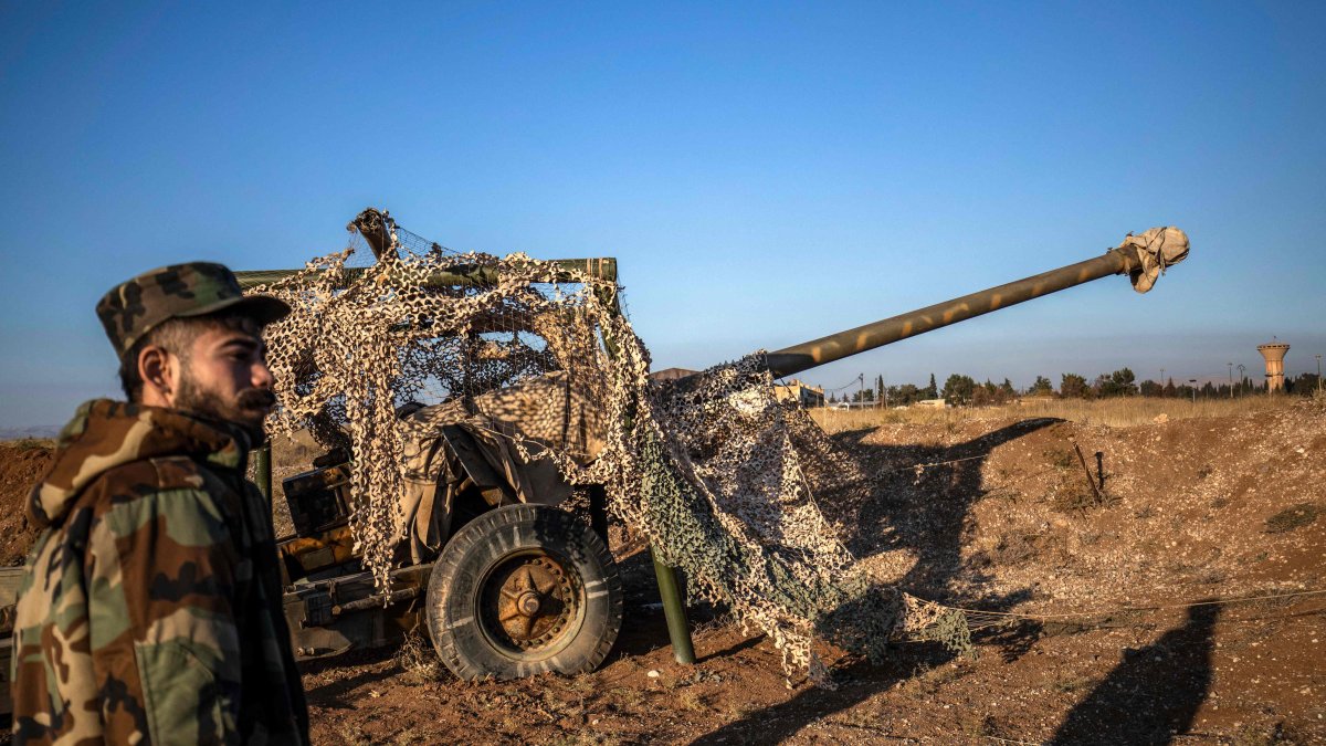 Terrorist YPG/PKK-led SDF fighter inspects damaged and abandoned military vehicles and equipment at the Qamishli International Airport, formerly a joint Syrian-Russian military base, in northeastern Syria&#039;s city of Qamishli on Dec. 9, 2024. (AFP Photo)