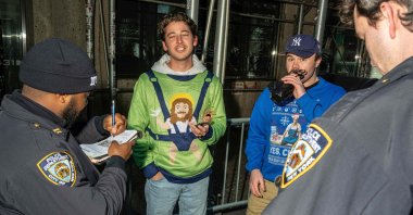 Participants of Santacon receive a citation for open alcohol containers in New York City, Dec. 14, 2024. (AFP Photo)