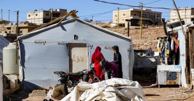 Syrian refugees stand outside a tent about to be dismantled at a camp in Arsal in eastern Lebanon before returning to Syria, Dec. 16, 2024. (AFP Photo)