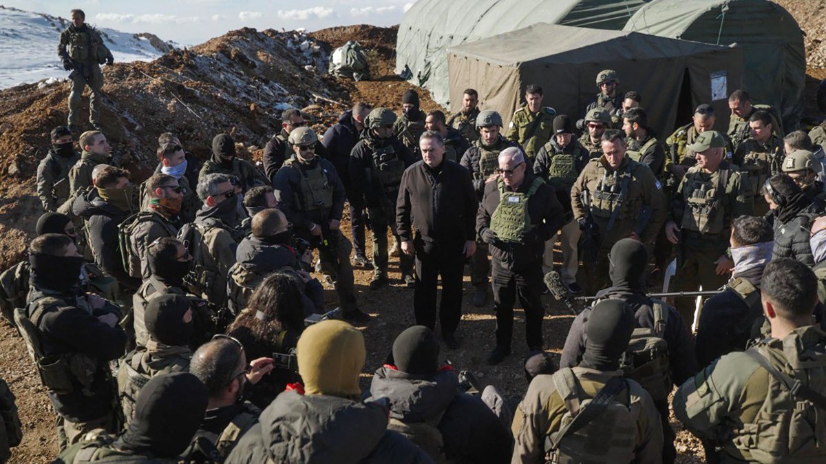 Israeli Prime Minister Benjamin Netanyahu (C-R) and Defense Minister Israel Katz (C-L) stand among Israeli troops at Jabal al-Shaykh or Mount Hermon in the occupied Golan Heights, Syria, Dec. 17, 2024.