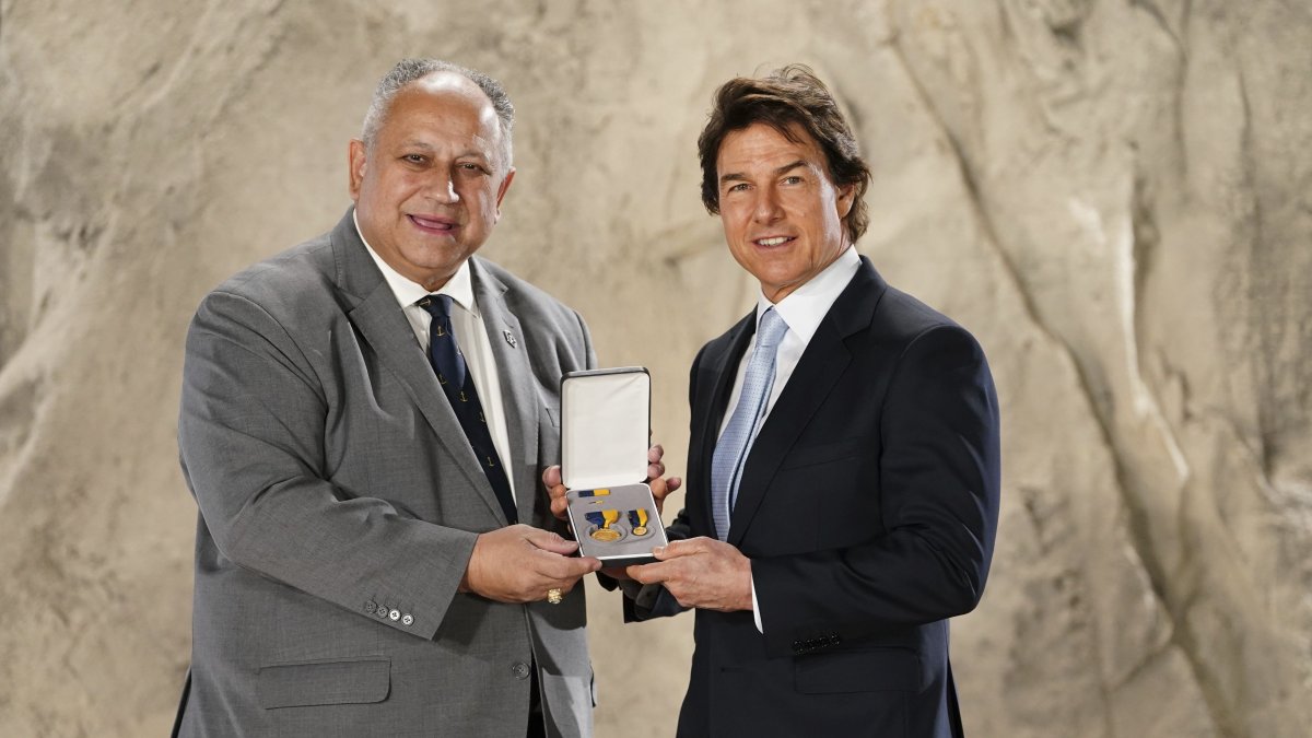 Actor Tom Cruise (R), is presented with the US Navy Distinguished Public Service Award by U.S. secretary of the Navy, Carlos Del Toro, during a ceremony at Long Cross Studios in Chertsey, Surrey, U.K., Dec. 17, 2024. (AP Photo)