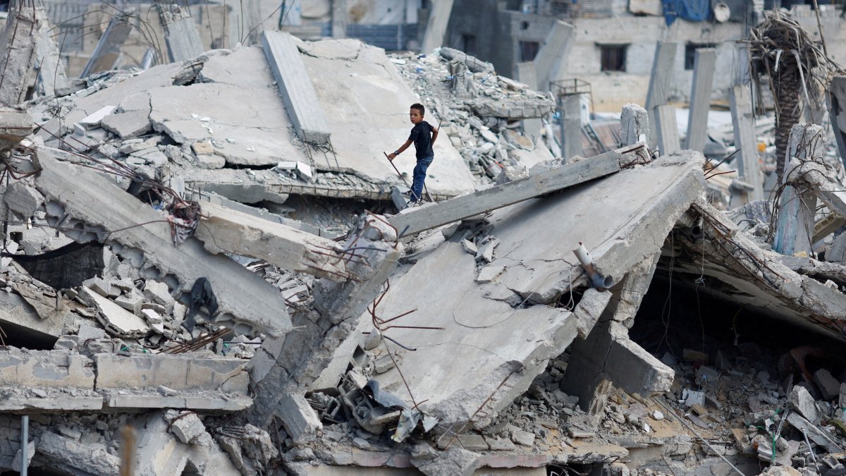 A Palestinian boy stands on the rubble of a house destroyed in Israeli attack, in Khan Younis, southern Gaza Strip, Palestine, Oct. 7, 2024. (Reuter Photo)