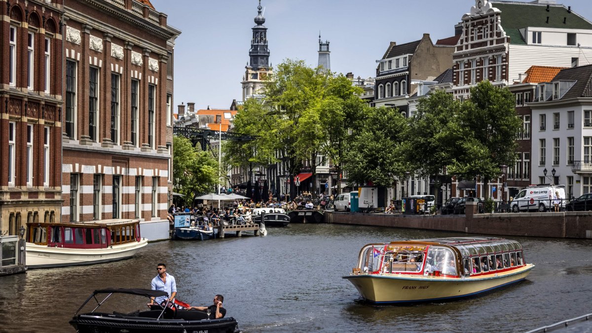 Passengers ride on a tour boat along a canal as a heat wave spreads across Europe, Amsterdam, Netherlands, June 17, 2022. (AFP Photo)