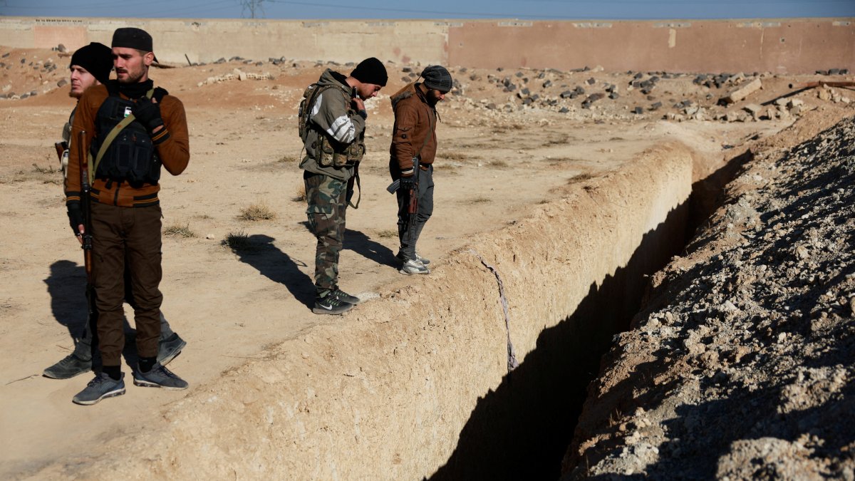 Fighters of the ruling Syrian body inspect the site of a mass grave from the rule of Syria&#039;s Bashar Assad, according to residents, in Najha, Syria, Dec. 17, 2024. (Reuters Photo)