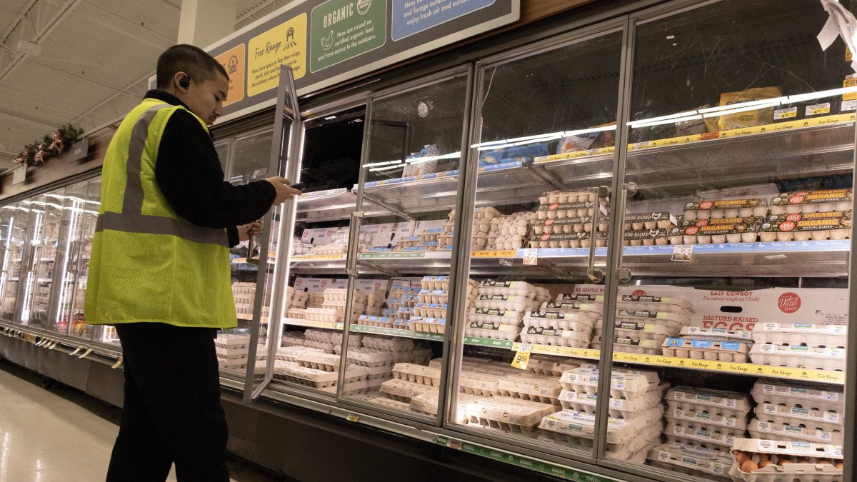 A man checks on cartooned eggs at a grocery store in Alameda, California, Dec. 11, 2024. (EPA Photo)