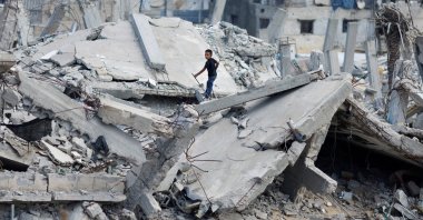 A Palestinian boy stands on the rubble of a house destroyed in Israeli attack, in Khan Younis, southern Gaza Strip, Palestine, Oct. 7, 2024. (Reuter Photo)