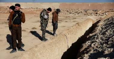Fighters of the ruling Syrian body inspect the site of a mass grave from the rule of Syria&#039;s Bashar Assad, according to residents, in Najha, Syria, Dec. 17, 2024. (Reuters Photo)