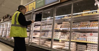 A man checks on cartooned eggs at a grocery store in Alameda, California, Dec. 11, 2024. (EPA Photo)